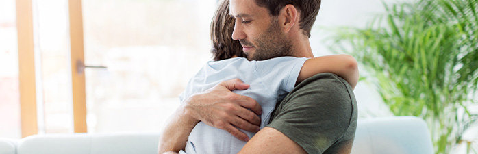 Father hugging sick child.